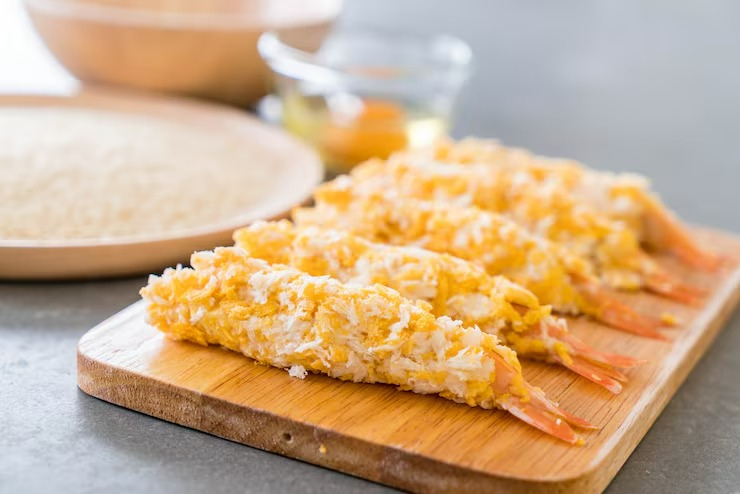 tôm tẩm bột panko trước khi chiên trên thớt gỗ